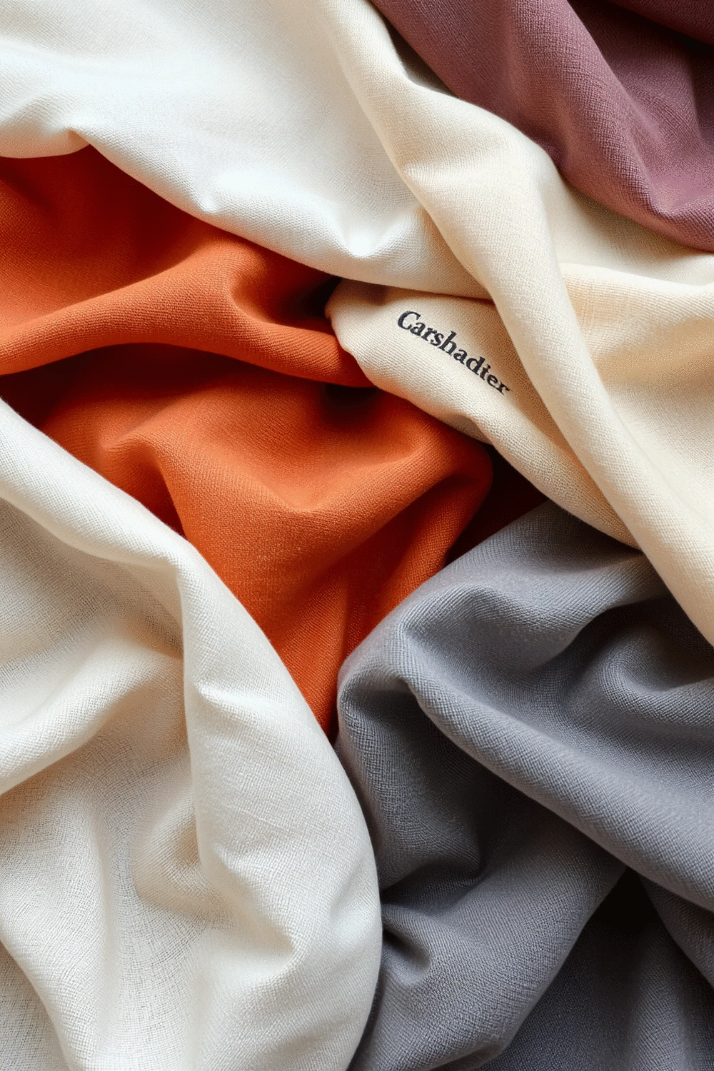Various fabric swatches of linen, velvet, and sheer materials arranged neatly, showcasing different textures and colors.